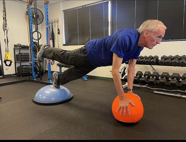 older man balancing on ball
